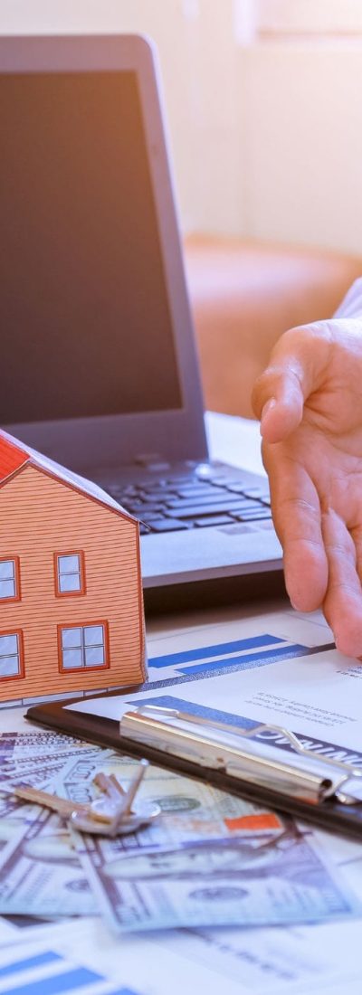 Real Estate Deal: Computer, House Model, Money, Keys, and Contract Real estate transaction scene with a computer, house model, money, keys, hand explaining, and a contract, representing the home buying process in Calgary.
